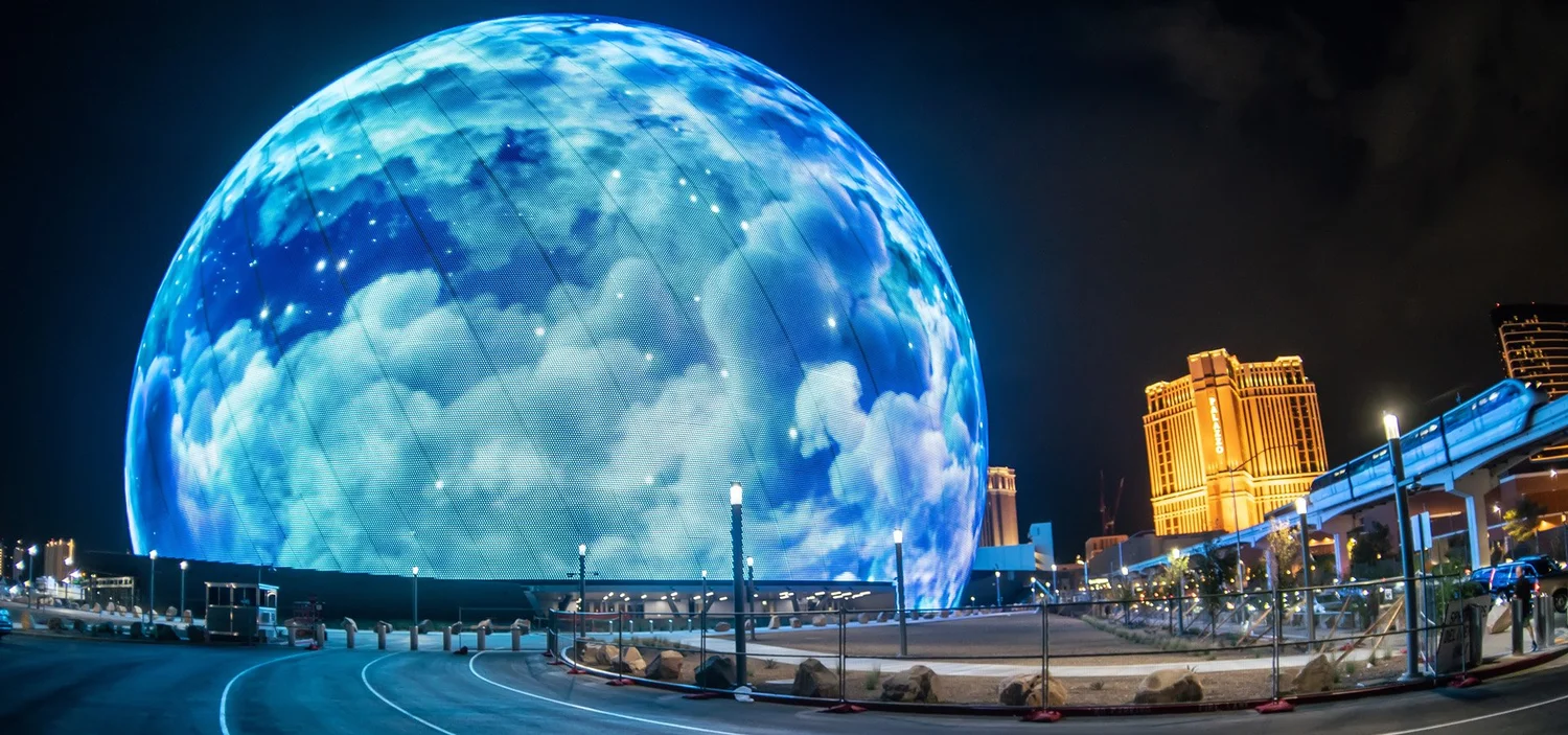 The Las Vegas Sphere at night, its LED exterior showing the Earth wrapped in clouds.