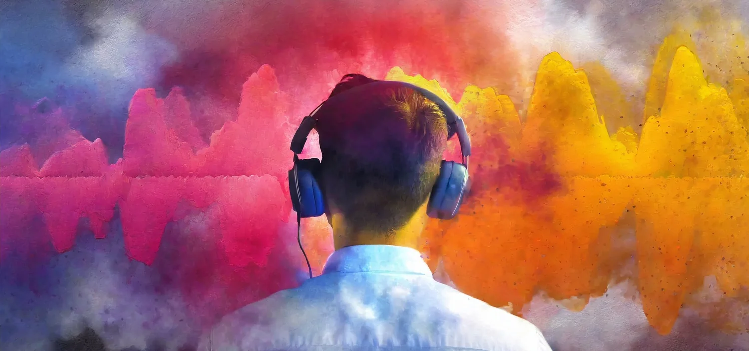 A person in headphones seen from behind, facing bright pink and yellow sound waves.