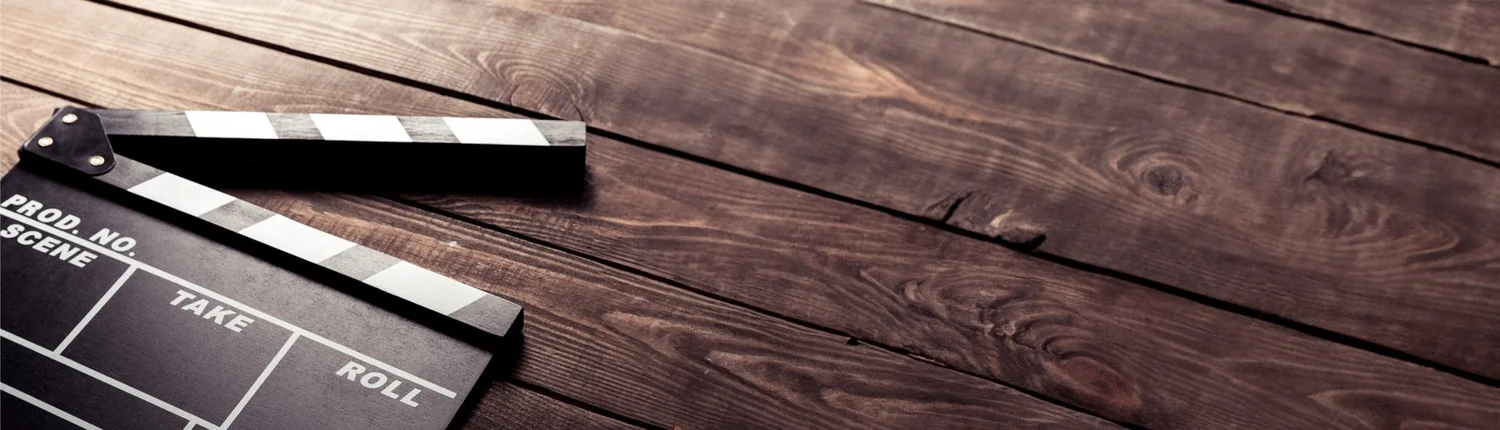 A film clapperboard lying on dark wooden boards.