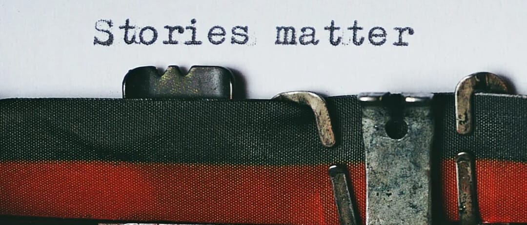 Close-up of a vintage typewriter with a sheet of paper reading "Stories matter".