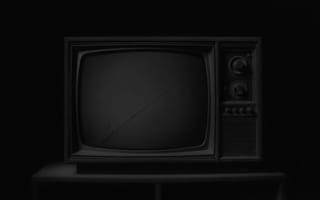 An old television set switched off in a dark room.