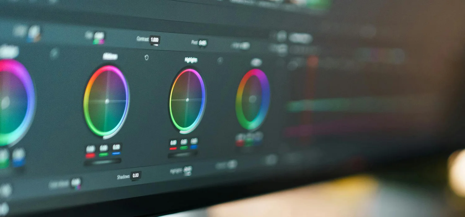 Close-up of colour-grading wheels on an editing screen.